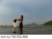 Fishermen using traditional fishing equipment After catching fish, clean up and play in the water. Стоковое фото, агентство Ingram Publishing / Фотобанк Лори