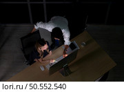 Top view of young Asian broker international stock traders working together on desktop at night office, International financial investment company concept. Стоковое фото, агентство Ingram Publishing / Фотобанк Лори