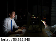 Both of young Asian broker international stock traders working together on desktop at night office, International financial investment company concept. Стоковое фото, агентство Ingram Publishing / Фотобанк Лори