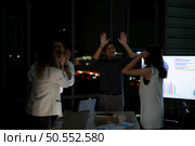 Group of broker international stock traders working actively at night in office, Everyone is congratulating the team on their success. Стоковое фото, агентство Ingram Publishing / Фотобанк Лори