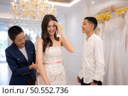 Bridal gown designers and tailors measure the size of the gown against the bride’s figure when she comes to try on the gown in order to make it perfect and ready to wear on the wedding day. Стоковое фото, агентство Ingram Publishing / Фотобанк Лори