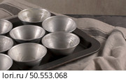Baking forms smeared with butter prepared to egg tarts, traditional portuguese dessert, pastel de nata, custard tarts home production. Стоковое фото, агентство Ingram Publishing / Фотобанк Лори
