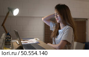 A young woman works on her laptop at home. It is characterized with headaches that occur when stressed. Стоковое фото, агентство Ingram Publishing / Фотобанк Лори