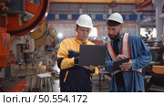Engineer and technician discussing machinery in factory to plan inspection maintenance according to usage cycle, Concepts inspections based on usage cycle maintenance. Стоковое фото, агентство Ingram Publishing / Фотобанк Лори