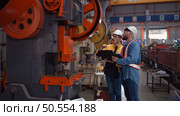 Engineer and technician discussing machinery in factory to plan inspection maintenance according to usage cycle, Concepts inspections based on usage cycle maintenance. Стоковое фото, агентство Ingram Publishing / Фотобанк Лори