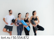 A group of female and male athletes stood and chatted amicably in the studio before beginning with the yoga class. Стоковое фото, агентство Ingram Publishing / Фотобанк Лори