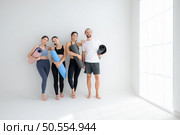 A group of female and male athletes stood and chatted amicably in the studio before beginning with the yoga class. Стоковое фото, агентство Ingram Publishing / Фотобанк Лори