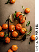 Mandarin oranges, clementines or tangerines with leaves on a dark background, top view. Стоковое фото, агентство Ingram Publishing / Фотобанк Лори
