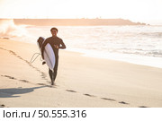 Man surfer run in the beach near the ocean with surfboard. Стоковое фото, агентство Ingram Publishing / Фотобанк Лори