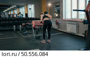 Rear view of young female doing exercises in gym.Sportwear. Стоковое фото, агентство Ingram Publishing / Фотобанк Лори