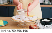 Woman sprinkling and decorating cookies with powdered sugar. Стоковое фото, агентство Ingram Publishing / Фотобанк Лори