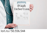 Doctor holding Paper Pad with Text Staph Infection. Стоковое фото, агентство Ingram Publishing / Фотобанк Лори