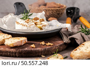 Brie type of cheese. Camembert cheese. Fresh sliced Brie cheese on a wooden tray with nuts, honey and leaves. Italian, French cheese. Стоковое фото, агентство Ingram Publishing / Фотобанк Лори