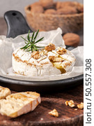 Brie type of cheese. Camembert cheese. Fresh sliced Brie cheese on a wooden tray with nuts, honey and leaves. Italian, French cheese. Стоковое фото, агентство Ingram Publishing / Фотобанк Лори