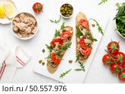 Tuna caper toasts with arugula, tomatoes and whole rye bread, top view. Стоковое фото, агентство Ingram Publishing / Фотобанк Лори