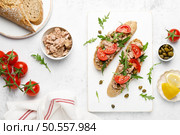 Tuna caper toasts with arugula, tomatoes and whole rye bread, top view. Стоковое фото, агентство Ingram Publishing / Фотобанк Лори