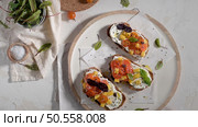 Italian bruschettas with roasted tomatoes, mozzarella cheese, pineapple slices and herbs on a rustic kitchen countertop. Стоковое фото, агентство Ingram Publishing / Фотобанк Лори