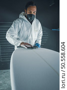 Surfboard manufacturing, Shaper working on board details. Concept of industrial manufacturing, qualified professional, occupation and employment. Стоковое фото, агентство Ingram Publishing / Фотобанк Лори