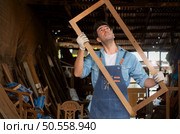 Carpenter working at his carpentry shop. Eyesight is utilized to ensure accuracy. Стоковое фото, агентство Ingram Publishing / Фотобанк Лори