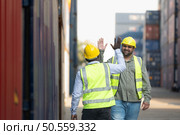 Both of workers in a container storage yard greeting each other during breaks in front of container warehouse, Стоковое фото, агентство Ingram Publishing / Фотобанк Лори