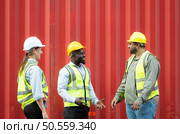 Group of workers in a container storage yard greeting each other during breaks in front of container warehouse, Стоковое фото, агентство Ingram Publishing / Фотобанк Лори