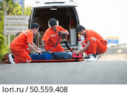The paramedic  is assisting an injured man in an emergency situation on the road. Стоковое фото, агентство Ingram Publishing / Фотобанк Лори