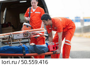 The paramedic  is assisting an injured man in an emergency situation on the road. Стоковое фото, агентство Ingram Publishing / Фотобанк Лори