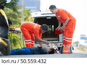 The paramedic  is assisting an injured man in an emergency situation on the road. Стоковое фото, агентство Ingram Publishing / Фотобанк Лори