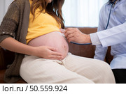 Asian pregnant woman visit gynecologist doctor at medical clinic for pregnancy consultant. Doctor examine pregnant belly for baby and mother healthcare check up. Стоковое фото, агентство Ingram Publishing / Фотобанк Лори