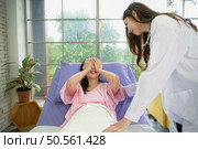Female doctor with IV equipment will give IV fluids and examine patients lying in hospital beds. Стоковое фото, агентство Ingram Publishing / Фотобанк Лори