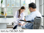 A doctor uses a reflex hammer to evaluate a patient’s knee joint. Стоковое фото, агентство Ingram Publishing / Фотобанк Лори