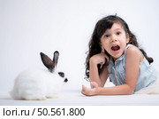Smiling little girl and with their beloved rabbit, showcasing the beauty of friendship between humans and animals. Стоковое фото, агентство Ingram Publishing / Фотобанк Лори