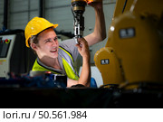 Technician who maintains a small robot arm the operation of a small robot arm used in industry is being repaired. Стоковое фото, агентство Ingram Publishing / Фотобанк Лори