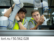 Group of engineers and technicians learning the technology to control hand robots for industrial usage. Стоковое фото, агентство Ingram Publishing / Фотобанк Лори