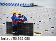 Photovoltaic engineers work on floating photovoltaics. Inspect and repair the solar panel equipment floating on the water. Стоковое фото, агентство Ingram Publishing / Фотобанк Лори