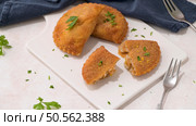 Meat patties and parsley leaves on white ceramic dishes in a kitchen counter top. Стоковое фото, агентство Ingram Publishing / Фотобанк Лори