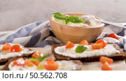 Rye bread bruschetta with cream cheese, olive oil and basil dip, cherry tomatoes, fresh basil leaves on wooden board. Стоковое фото, агентство Ingram Publishing / Фотобанк Лори