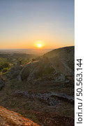 Warm sunset glow bathes rugged terrain, offering a serene expansive view. Guarda - Portugal. Стоковое фото, агентство Ingram Publishing / Фотобанк Лори