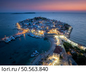Aeriel view of old town with street lights on island at night. Summer in Primosten, Croatia, Adriatic Sea. Top view of houses, purple sky,  water, city lights, boat, yachts, illuminated waterfront. Стоковое фото, агентство Ingram Publishing / Фотобанк Лори