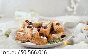 Cereal bars with almonds, coconut and cranberries on a Christmas season table decorated with lights and stars. Стоковое фото, агентство Ingram Publishing / Фотобанк Лори
