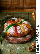 A festive King Cake adorned with colorful candied fruits, dusted with powdered sugar, and ready to be shared. Стоковое фото, агентство Ingram Publishing / Фотобанк Лори