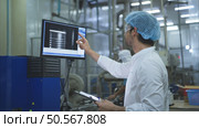 The production control supervisor inspects and controls the operation of machines in the manufacturing line of a canned fish industry. Стоковое фото, агентство Ingram Publishing / Фотобанк Лори