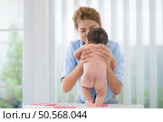 A mother bathes her little daughter in a small children’s tub. Стоковое фото, агентство Ingram Publishing / Фотобанк Лори