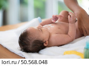 Following a bath, a mother applies powder and dresses her tiny daughter. Стоковое фото, агентство Ingram Publishing / Фотобанк Лори