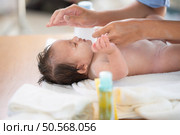 Following a bath, a mother applies powder and dresses her tiny daughter. Стоковое фото, агентство Ingram Publishing / Фотобанк Лори