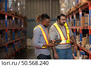 A group of warehouse employees, Inspecting products on warehouse shelves before they are sent to retailer. Стоковое фото, агентство Ingram Publishing / Фотобанк Лори