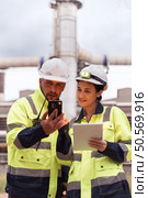 Both of Petroleum engineer is on a mission to inspect oil distillation at a huge oil refinery. Стоковое фото, агентство Ingram Publishing / Фотобанк Лори