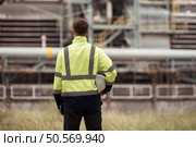 Petroleum engineer is on a mission to inspect oil distillation at a huge oil refinery. Стоковое фото, агентство Ingram Publishing / Фотобанк Лори