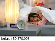 Asian young woman on the bed in the bedroom trying to wake up and prepare for work. Стоковое фото, агентство Ingram Publishing / Фотобанк Лори