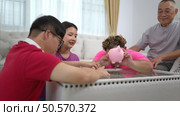 Three siblings save money by putting it in a piggy bank, This is an activity that parents teach their children about saving money. Стоковое фото, агентство Ingram Publishing / Фотобанк Лори